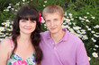 husband, wife with big red flower in hair in park