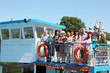 family of nine people walking on pleasure craft near cathedral