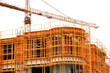 Building under construction and crane isolated on white