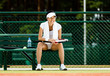 Successful female tennis player rests with bottle of water 