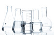 Five classic laboratory flasks with a clear liquid, isolated