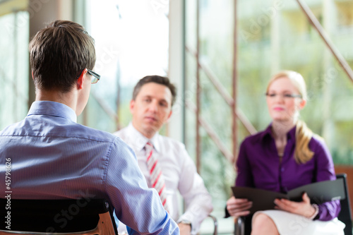 Photo: Man having an interview with manager and partner employment job Man having an interview with manager and partner employment job