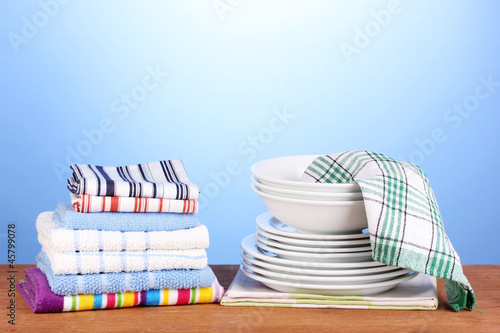 Photo: kitchen towels with dishes on blue background close-up kitchen towels with dishes on blue background close-up