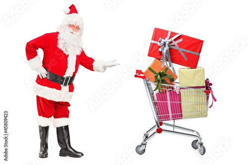 Photo: Santa Claus showing a shopping cart full of presents Santa Claus showing a shopping cart full of presents