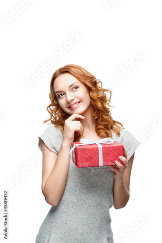 Photo: thoughtful young casual girl with red gift thoughtful young casual girl with red gift