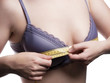 Young woman measures her Breast size - isolated
