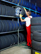 Car mechanic stores winter tire in a warehouse for tires