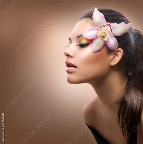 Photo: Beauty Portrait. Beautiful Stylish Girl with Orchid Flower Beauty Portrait. Beautiful Stylish Girl with Orchid Flower
