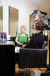 Mother has hair coloured watched by young daughter