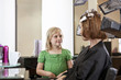 Mother has her hair coloured watched by young daughter