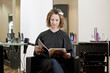 female client reading a magazine while she has her hair colored