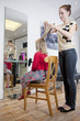 A female hairdresser cutting a young girls hair