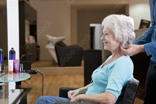 Photo: A senior woman in hairdressing salon admiring her new hairstyle A senior woman in hairdressing salon admiring her new hairstyle