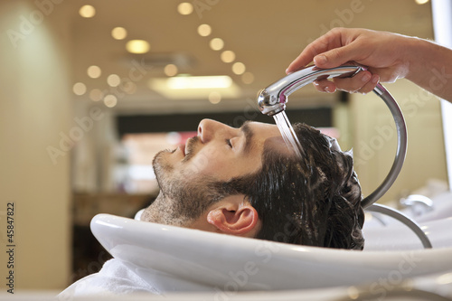 Photo: A male hairdresser rinsing a male clients hair A male hairdresser rinsing a male clients hair