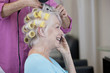 A senior woman talking on a mobile phone at the hairdressers