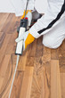 Photo: Appling silicone sealant in spaces of old wooden floor Appling silicone sealant in spaces of old wooden floor