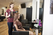 Client sees her new haircut in a mirror held by hairdresser