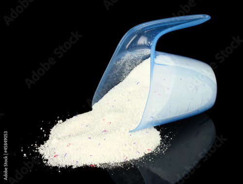 Photo: washing powder in a measuring cup, isolated on black washing powder in a measuring cup, isolated on black
