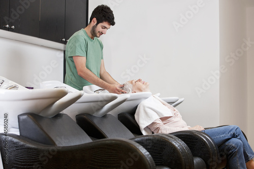 Photo: A male hairdresser shampooing a female clients hair A male hairdresser shampooing a female clients hair