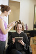 A woman having highlights in a salon and using a digital tablet