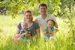 Photo: Big happy family, mother, father, children sitting on grass Big happy family, mother, father, children sitting on grass