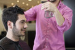 A male hairdresser spraying water on a male clients hair