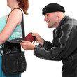 Thief stealing from handbag of a woman.