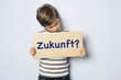Kind mit Schild fragt nach seiner Zukunft