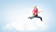Photo: young woman playing on electro guitar and jumping young woman playing on electro guitar and jumping