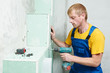 carpenter with plasterboard and screwdriver