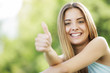Foto: Happy young woman showing thumbs up sign Happy young woman showing thumbs up sign