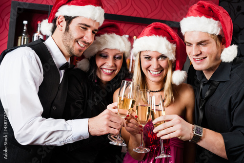 Photo: Christmas party friends at bar toast champagne Christmas party friends at bar toast champagne