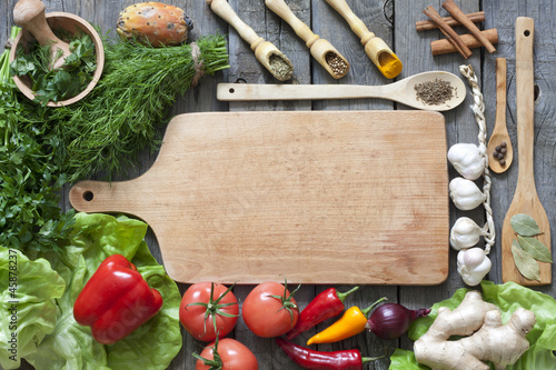 Photo: Vegetables and spices vintage border and empty cutting board Vegetables and spices vintage border and empty cutting board