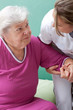 Pflegerin hilft Patientin beim aufstehen oder hinsetzen