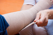 Foto: Pflegerin bandagiert den Fuss einer Patientin Pflegerin bandagiert den Fuss einer Patientin