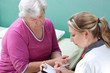 Photo: Ärztin notiert sich Daten zur Patientin Ärztin notiert sich Daten zur Patientin
