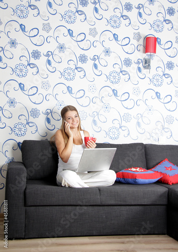 Photo: young happy smiling woman with laptop working at home young happy smiling woman with laptop working at home