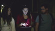 Three tourists friends with tablet in night city, steadicam shot
