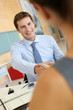 Business associates shaking hands in office
