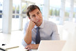 Businessman sitting in office with bored look