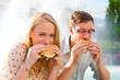 Photo: Paar hat Hunger und isst Burger in Pause Paar hat Hunger und isst Burger in Pause