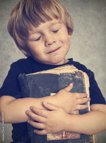 Photo: Little boy hugging an old book Little boy hugging an old book