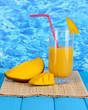 Ripe appetizing mango on woven napkin on water background