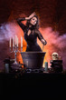 A sexy brunette witch making a mystical poison in a pot