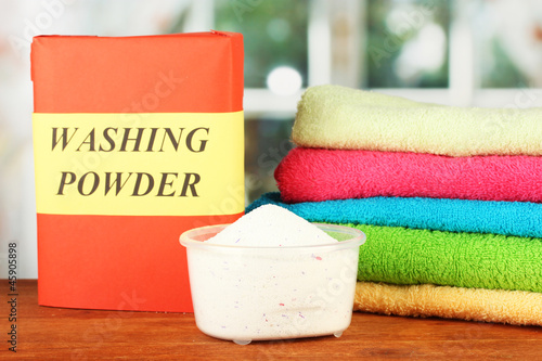 Photo: Box of washing powder with blue measuring cup and towels, Box of washing powder with blue measuring cup and towels,