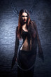 Halloween concept: young and sexy witch in dark clothes