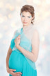 Young smiling pregnant woman in blue dress