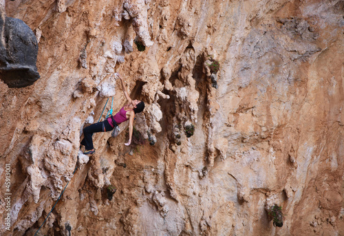 Photo: Female rock climber on a cliff face Female rock climber on a cliff face