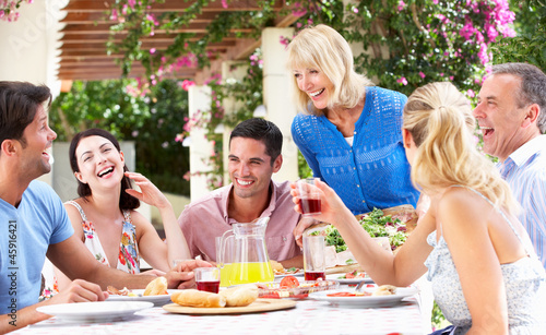 Photo: Group Of Young And Senior Couples Enjoying Family Meal Group Of Young And Senior Couples Enjoying Family Meal