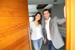 Couple opening the front door of their home